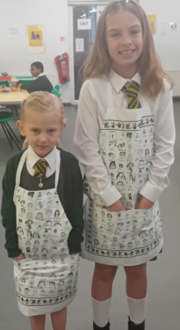 Breakfast club children are trying out the aprons.