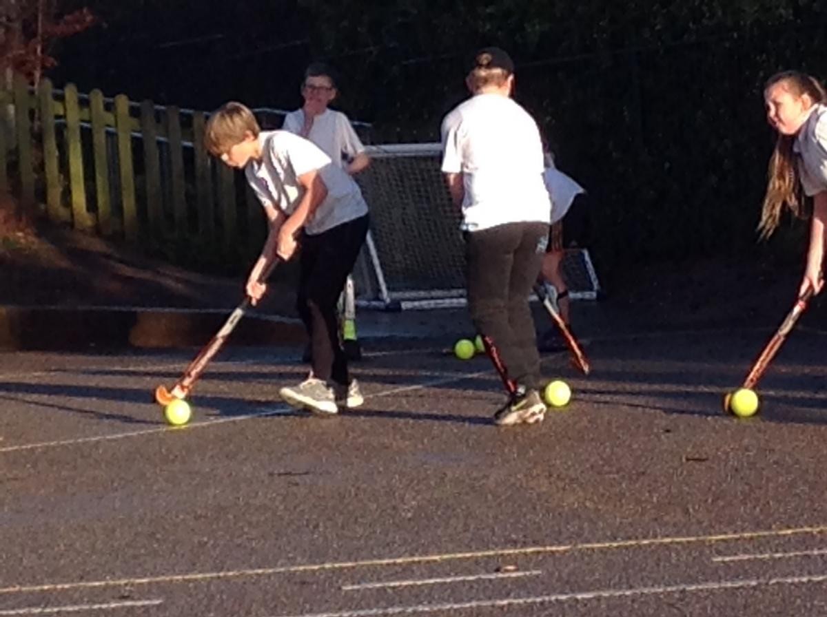 Working out how to dribble the ball and hold the hockey stick.