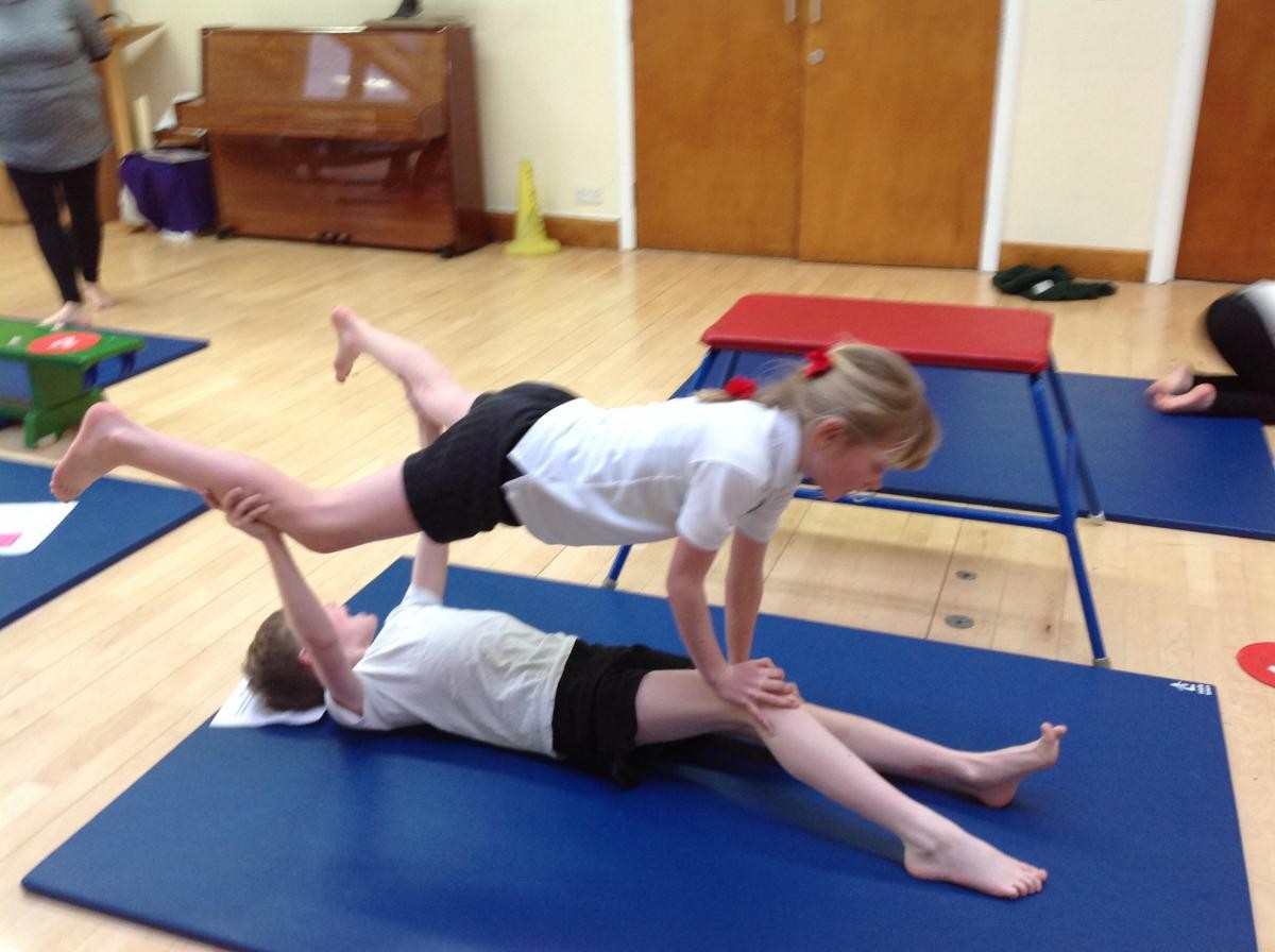 As  a class we helped this pair to improve their challenging partner balance. First tip bring the legs together, both children.