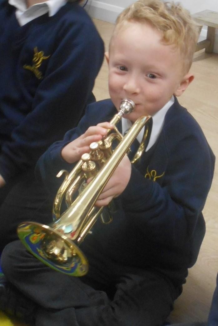 Enjoying having a go at playing the cornet.
