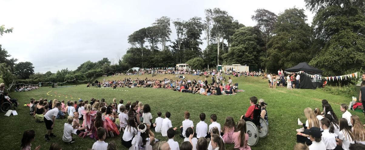 Children sat gathered on a field 