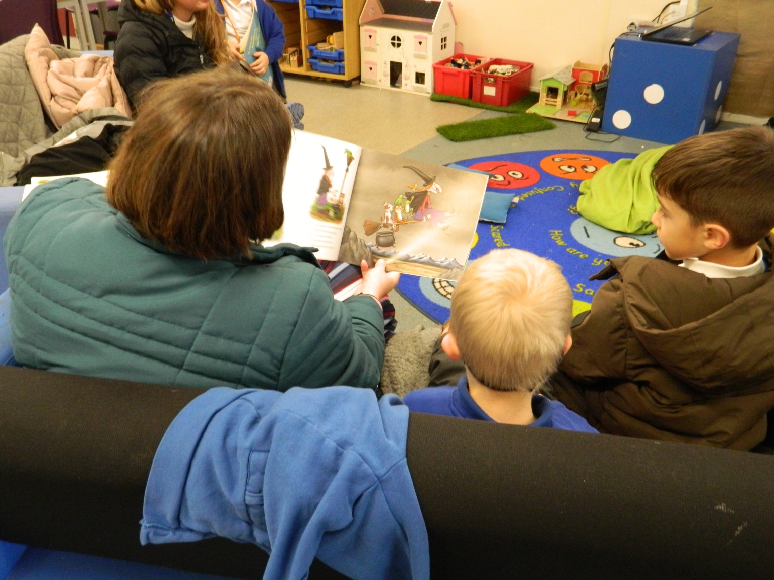 Children looking at a book with an adult