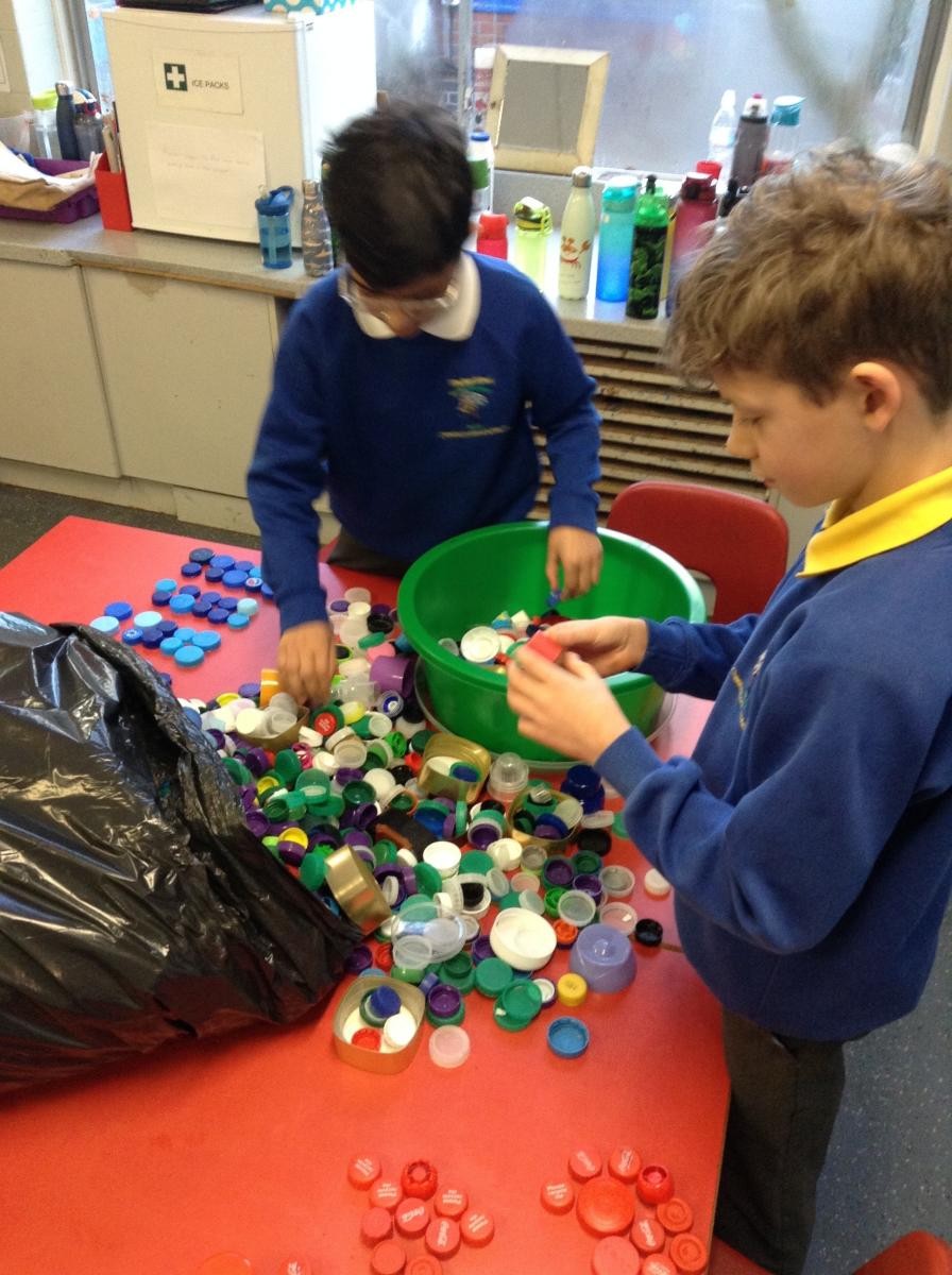 children sorting through coloured bottle lids