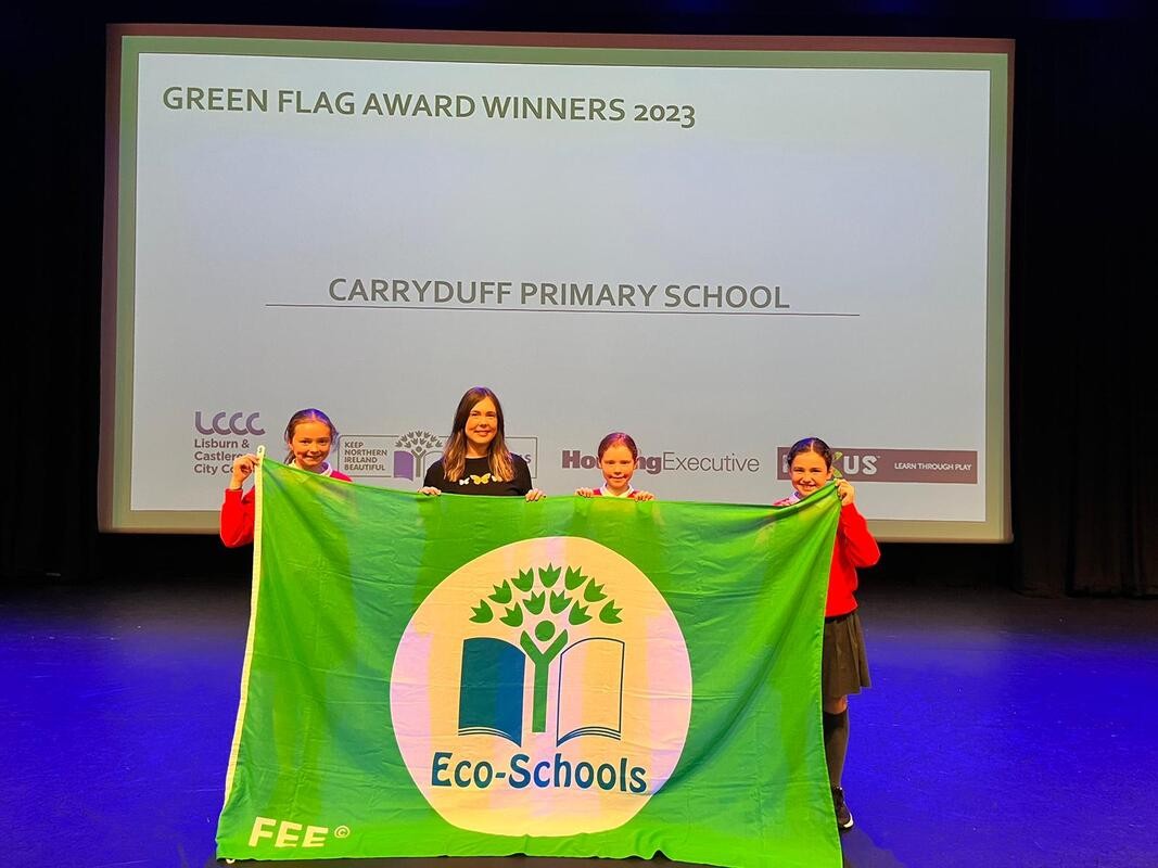 Children holding up a eco schools flag