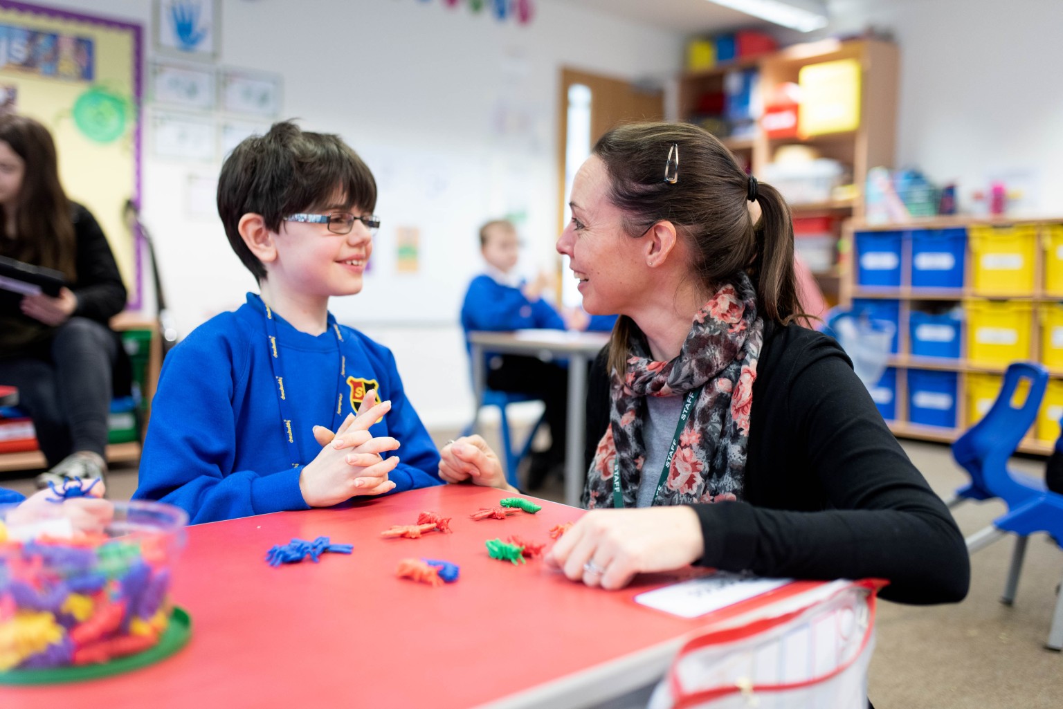 Child and adult looking at each other at a table 