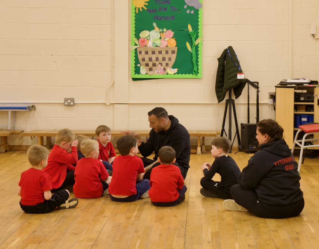 Children and adults sat in school hall