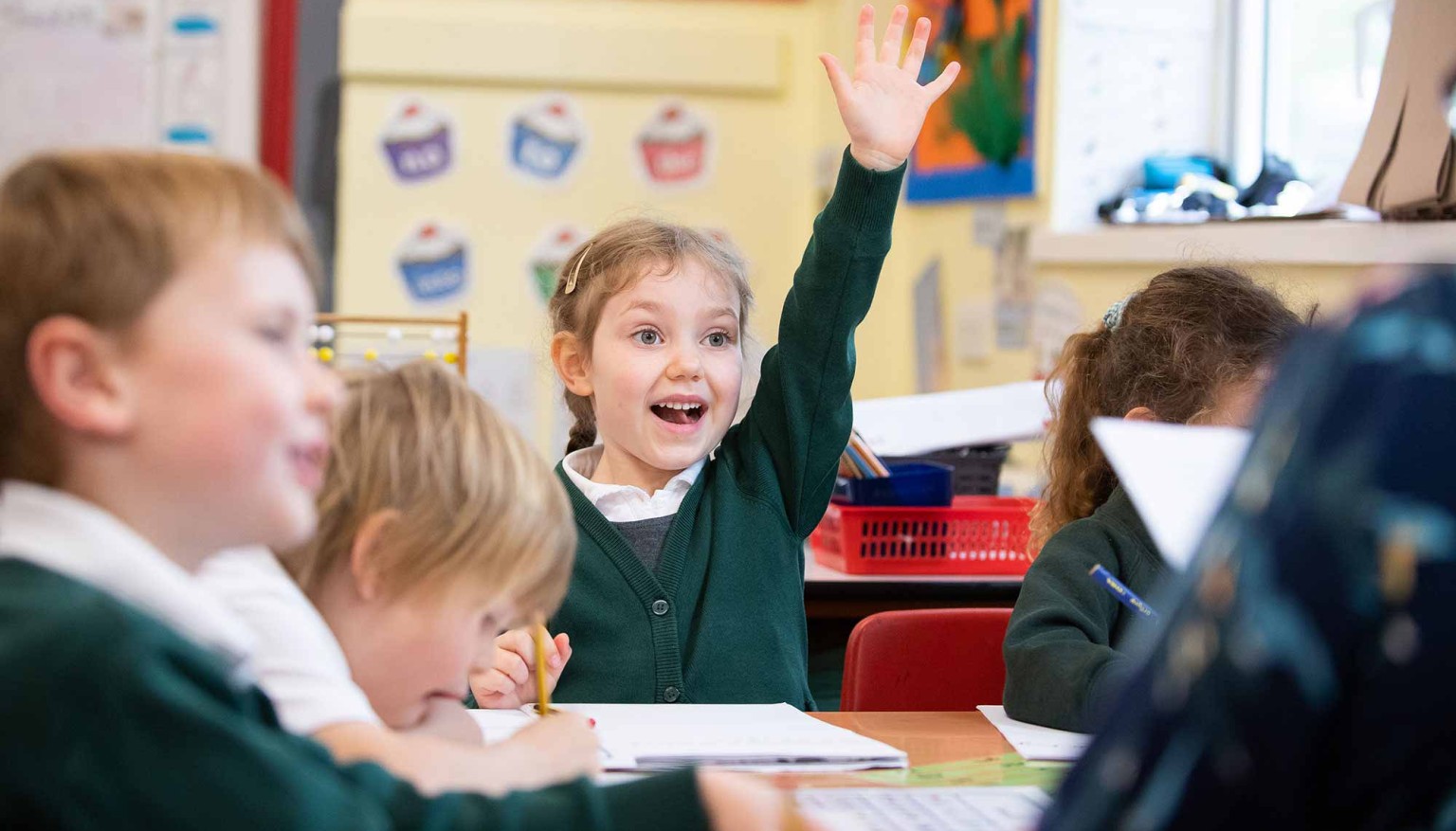 Child holding hand up to answer question