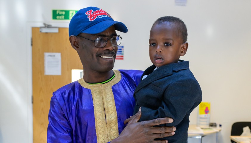 Father and son smile at the camera