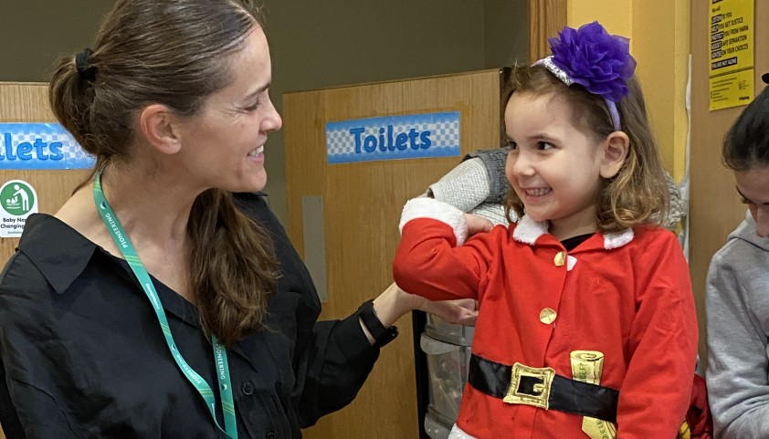 Child smiles with an early language practitioner