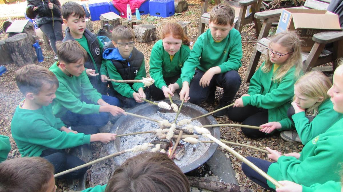 Pupils making bread around a fire