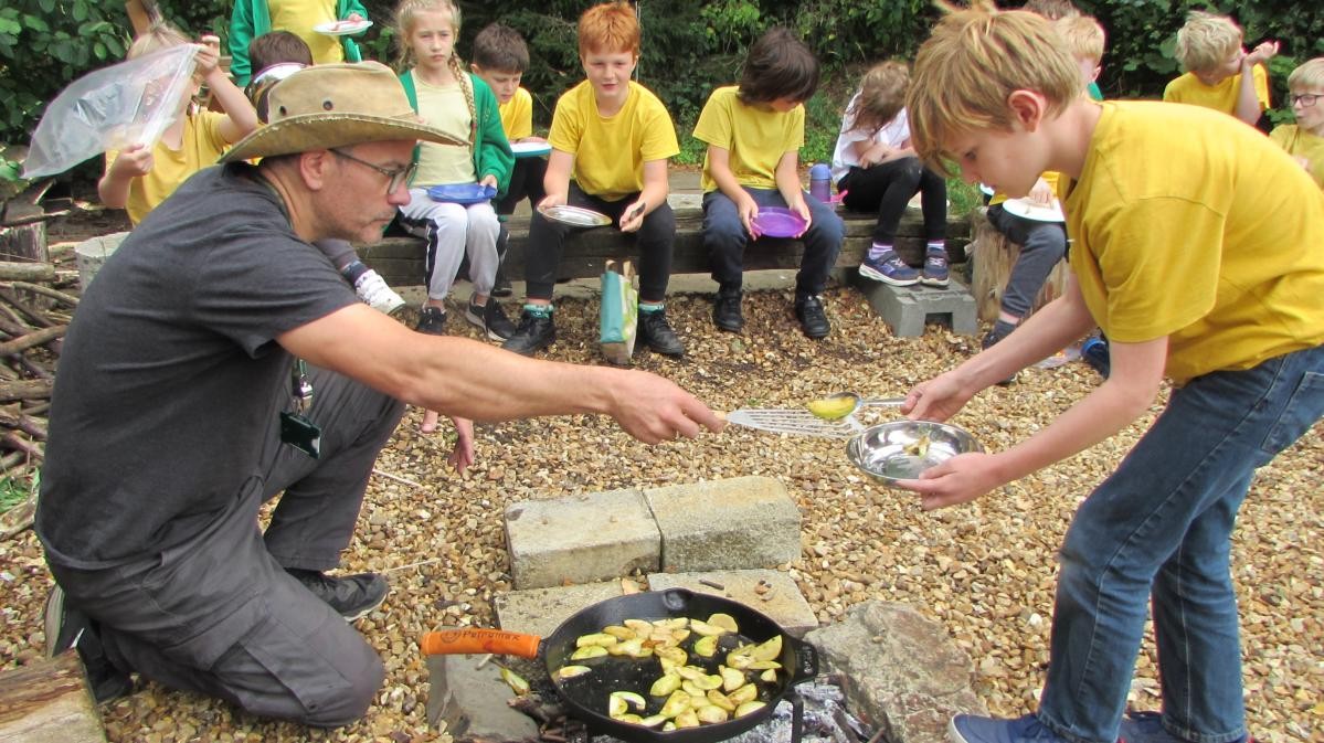 Pupils cooking around a campfire