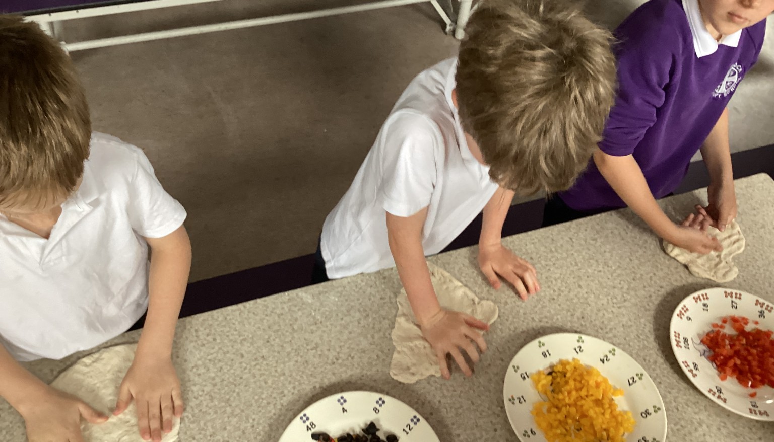 Pupils practised making a pizza base using fresh pizza dough, learning how to shape, stretch, and prepare it ready for toppings. 🍕👏