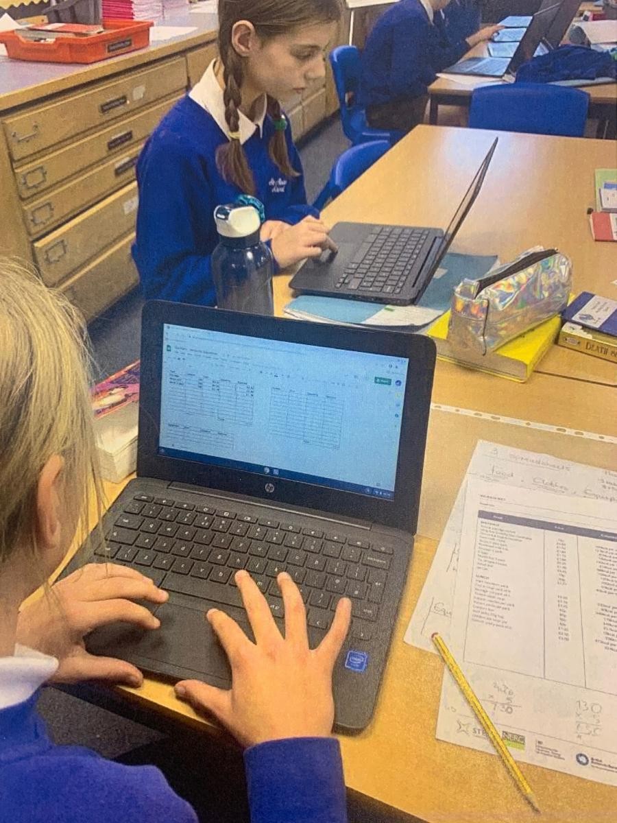Class 6 planning an Antarctic expedition, using Chrome books to create spreadsheets in a cross-curricular IT lesson.