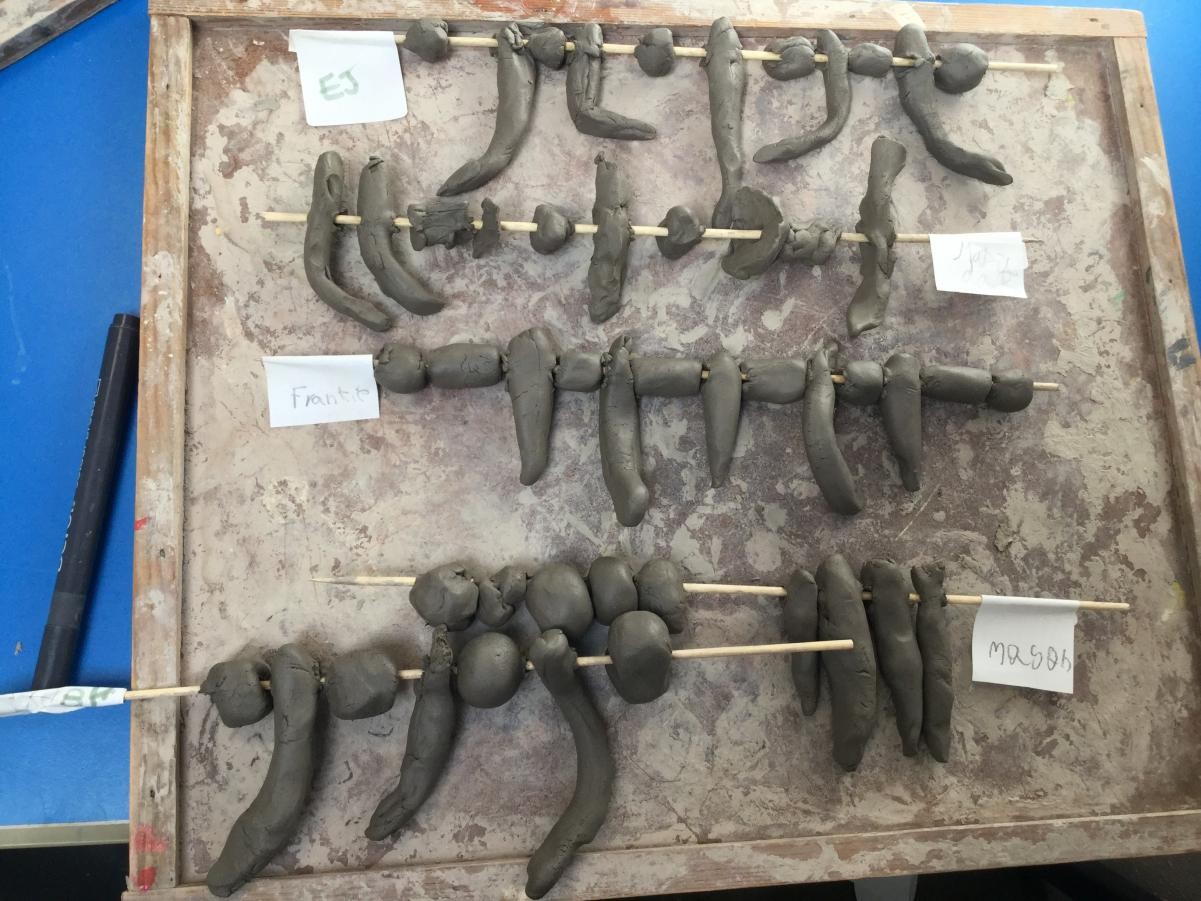 Sculpture. Shaping clay for Stone Age necklace beads