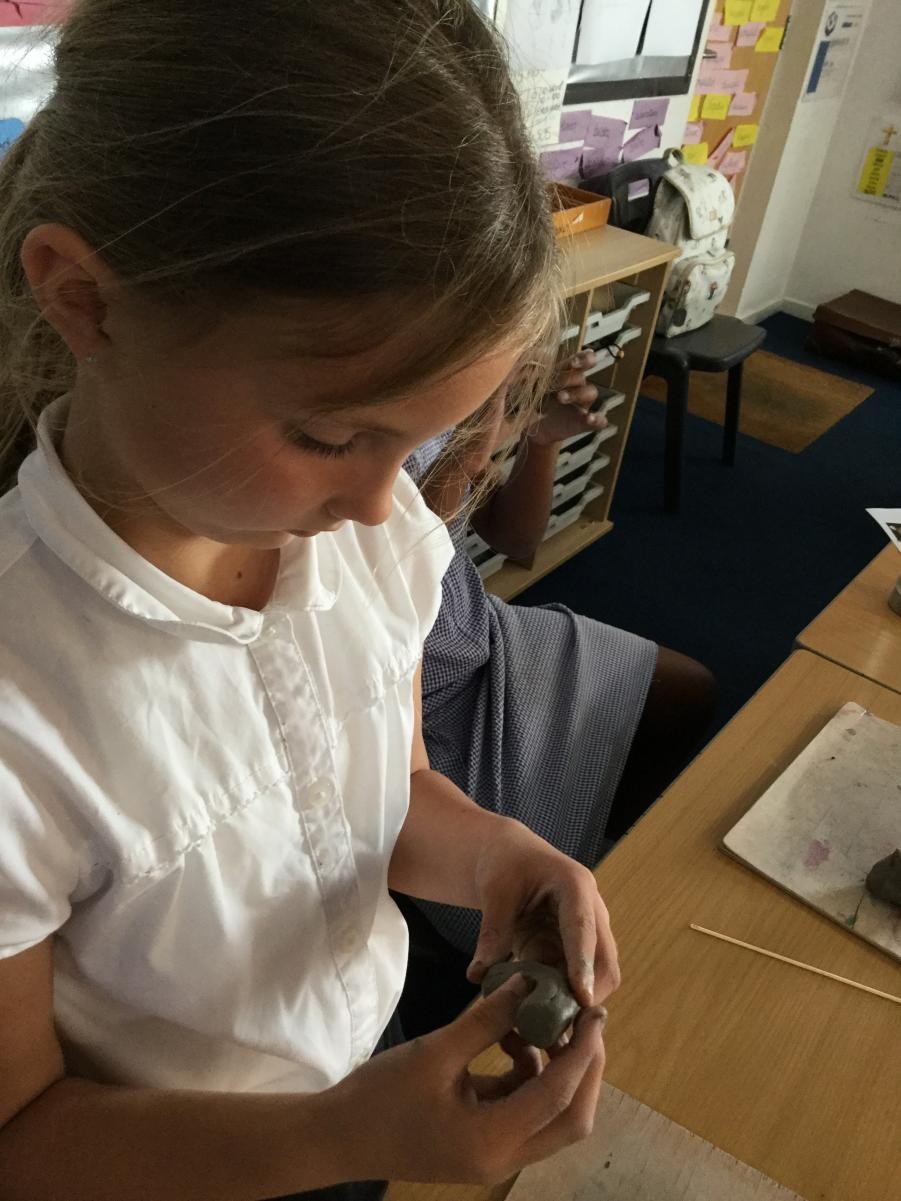 Sculpture. Shaping clay for Stone Age necklace beads