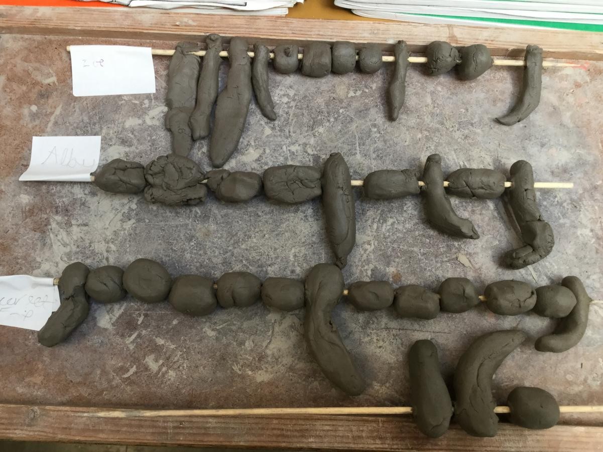 Sculpture. Shaping clay for Stone Age necklace beads