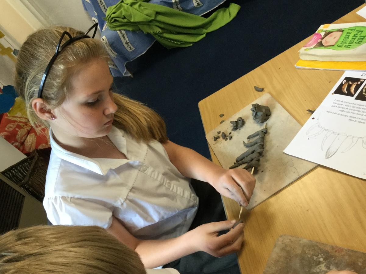 Sculpture. Shaping clay for Stone Age necklace beads