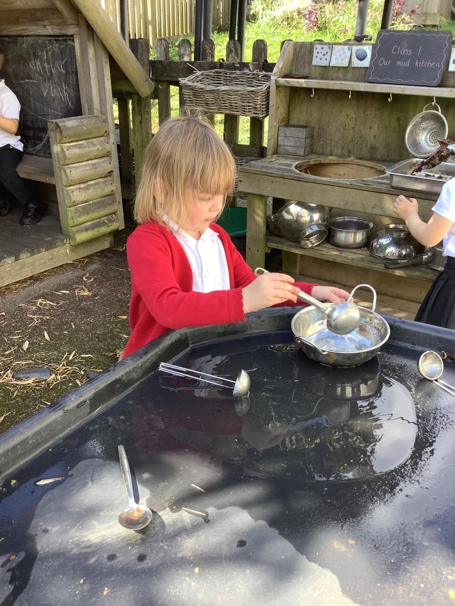 Outdoor Learning - using the spoons and scoops in our mud kitchen