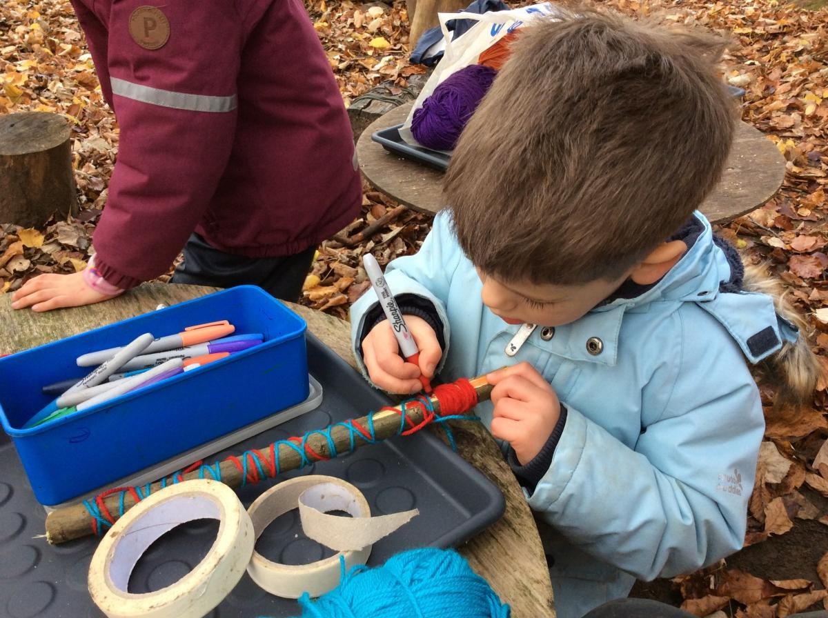 Decorating a stick to make a sword.