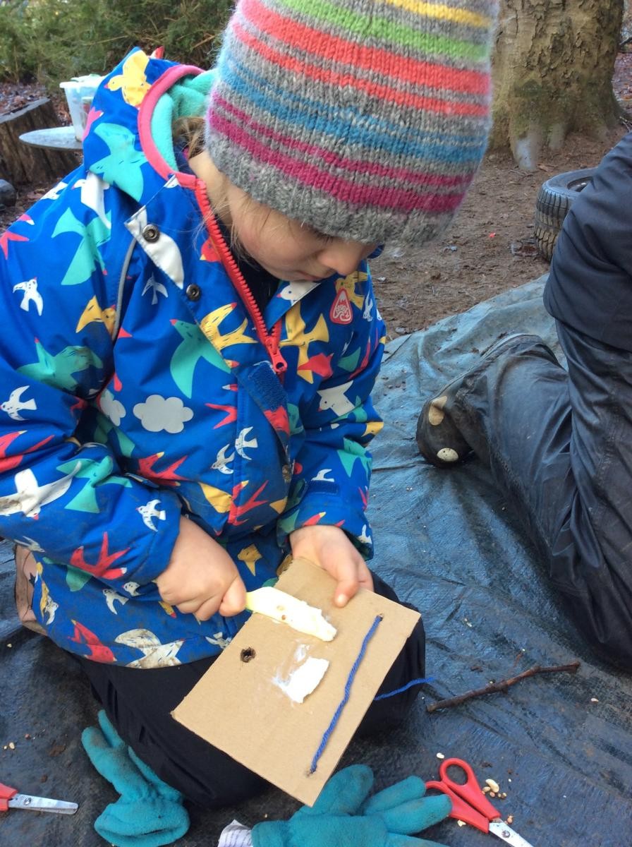 We threaded yarn through the holes then spread lard onto the cardboard.