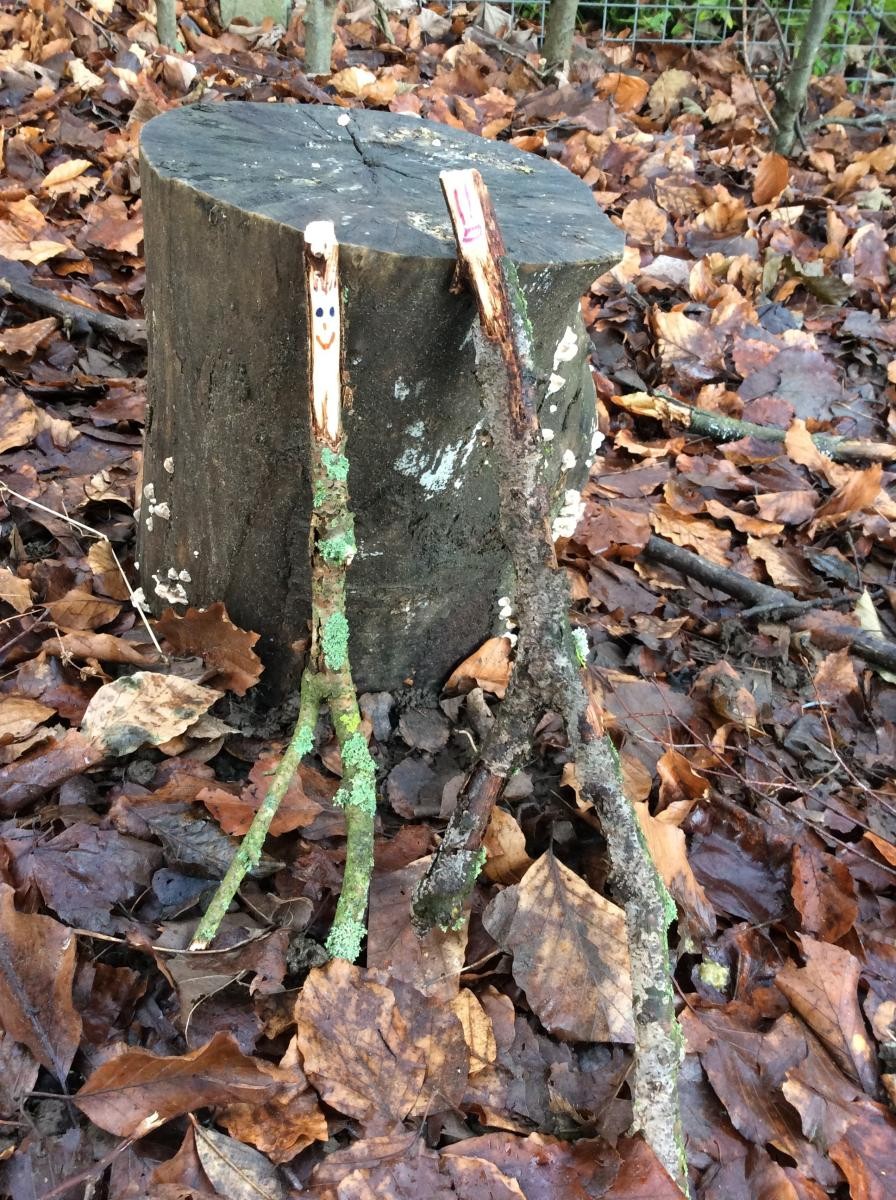 These two stick people are getting married by the log!