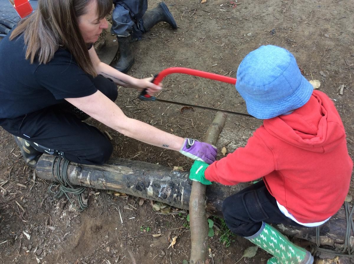 Using the bow saw, we cut a slice of wood off an old branch.
