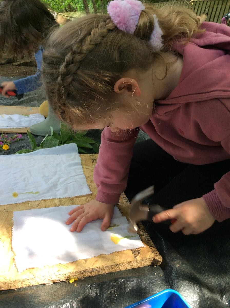 We put the flowers and leaves in between two layers of fabric and hit them gently with a hammer.