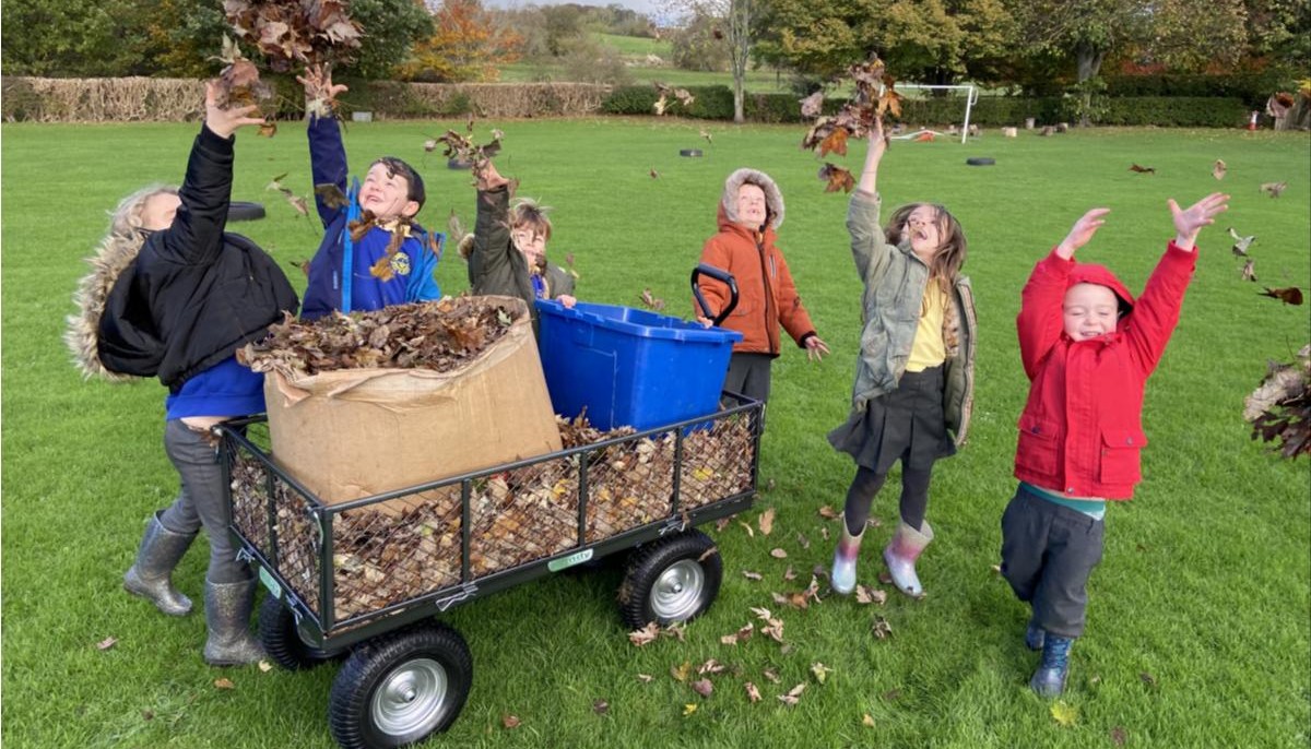 Children throuwing leaves into the air