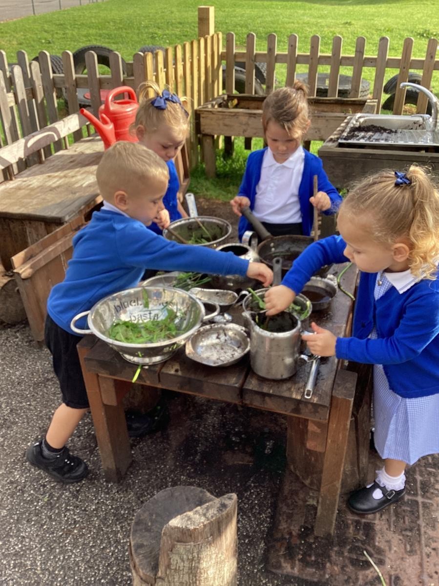 Children creating in the mud kitchen cafe.