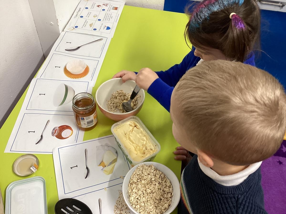 Nursery children baking flapjacks as part of the early maths curriculum. 