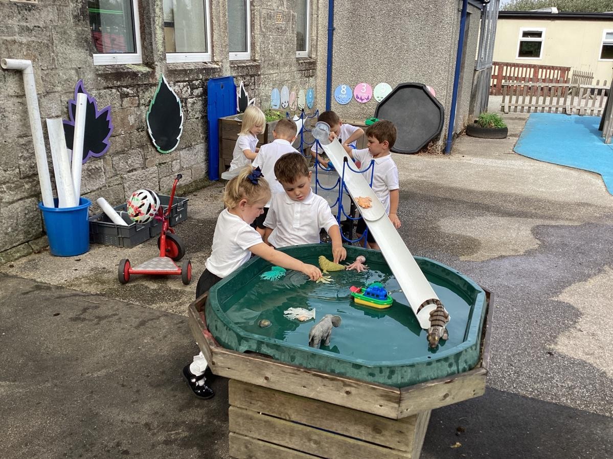 Nursery and reception children working together to create a water track. 