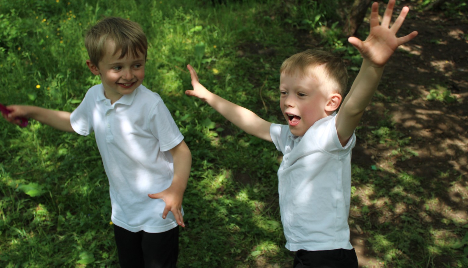Two children with arms in the air excited 