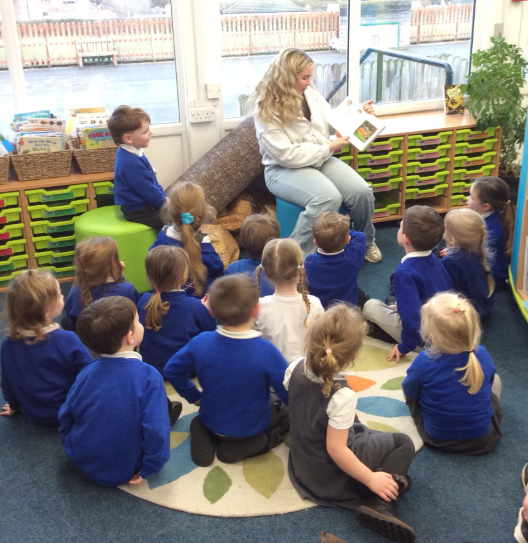 EYFS listening to a story read by the Mystery Reader