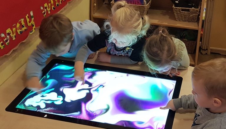 Children looking at light table 