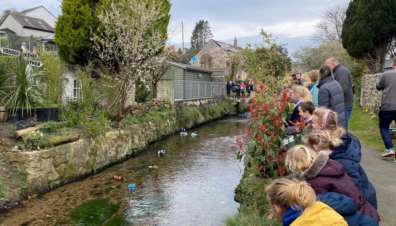 Boat race people looking over the wall at the river