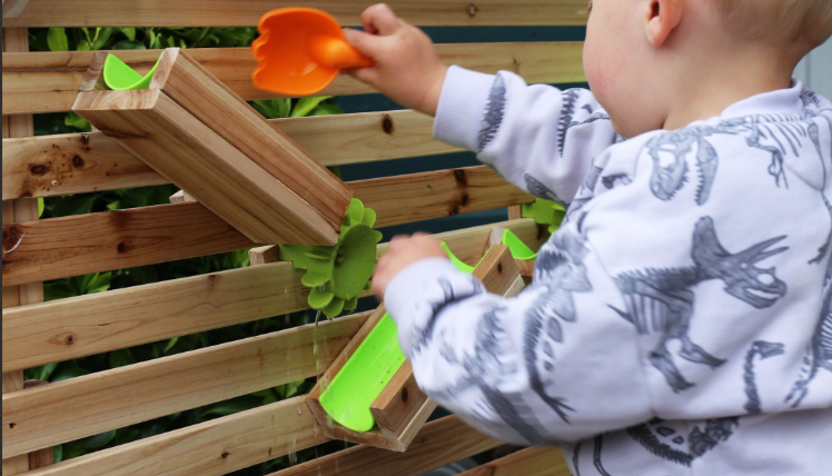 Child playing with a water wall