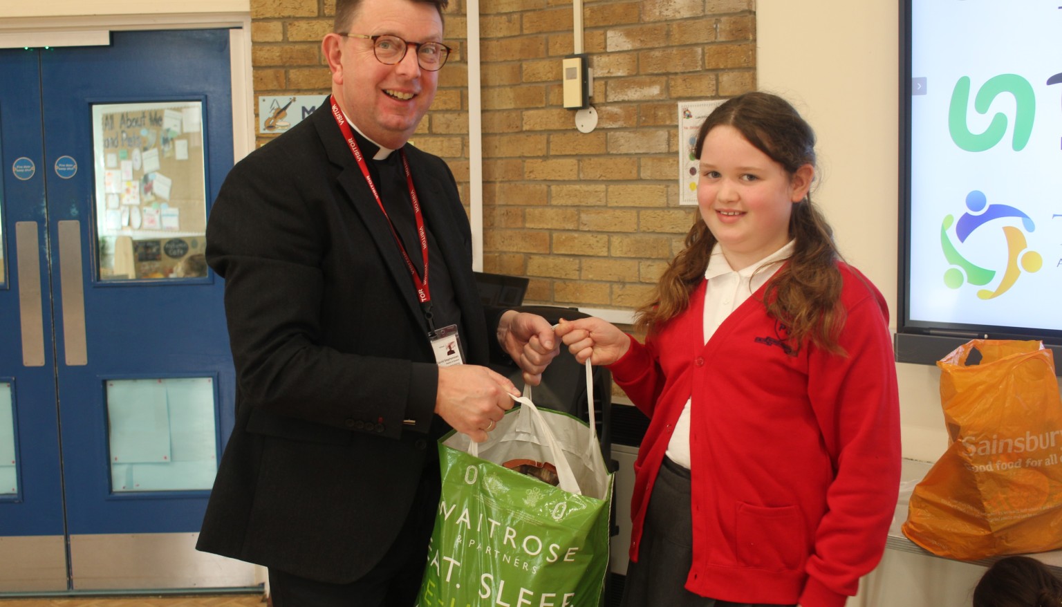 Father David receiving the donations for the Boston Food Bank from one of our School Councillors