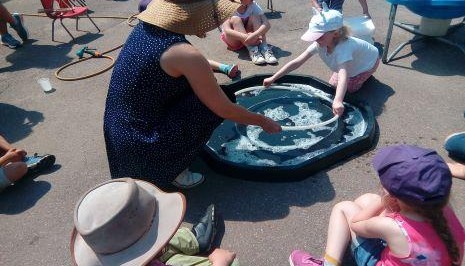 Adult and children in tuff tray playing 