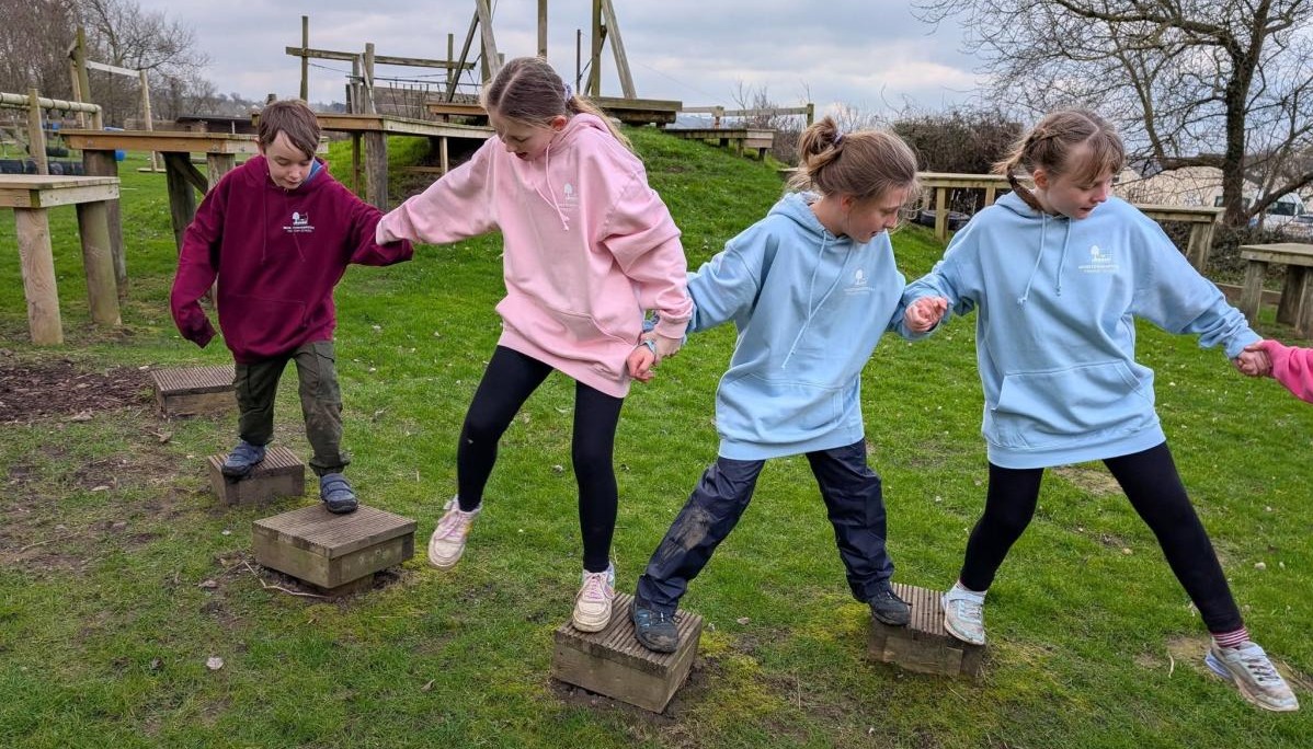 children balancing along boxes 