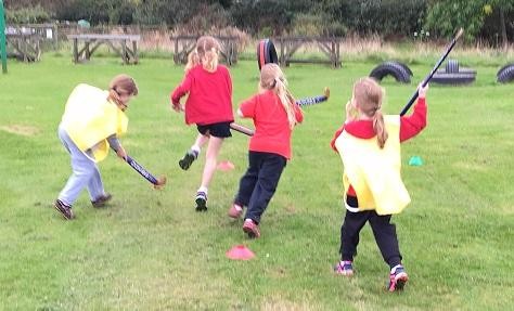 Team games playing hockey in KS2