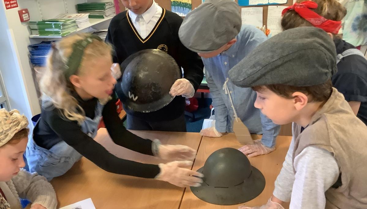 Children looking at war helmets 