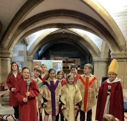 Children taking part in a workshop at Truro Cathedral, investigating the clothing worn during religious ceremonies.