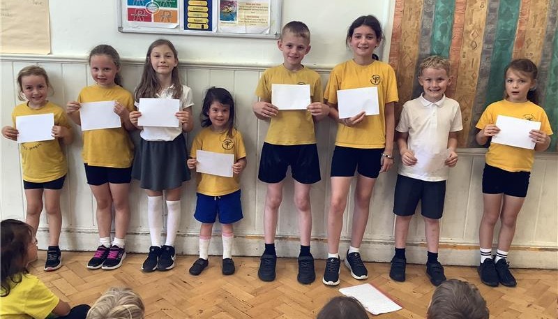 A row of children holding up pieces of paper