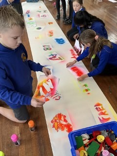 Oak Class creating some amazing draft street art images using spray paint.