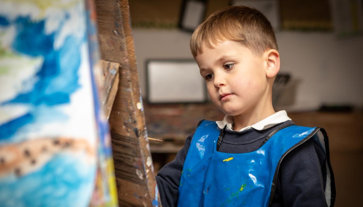 Child looking at painting easel 