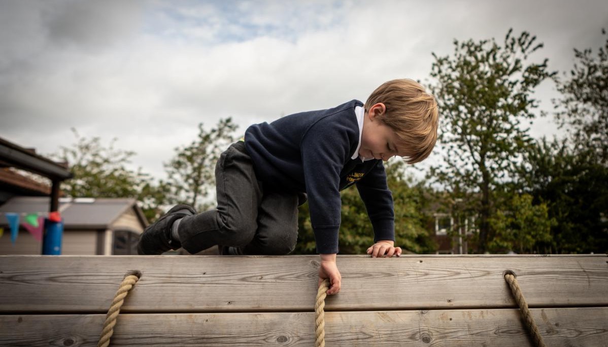 Child crawling along wooden platform 