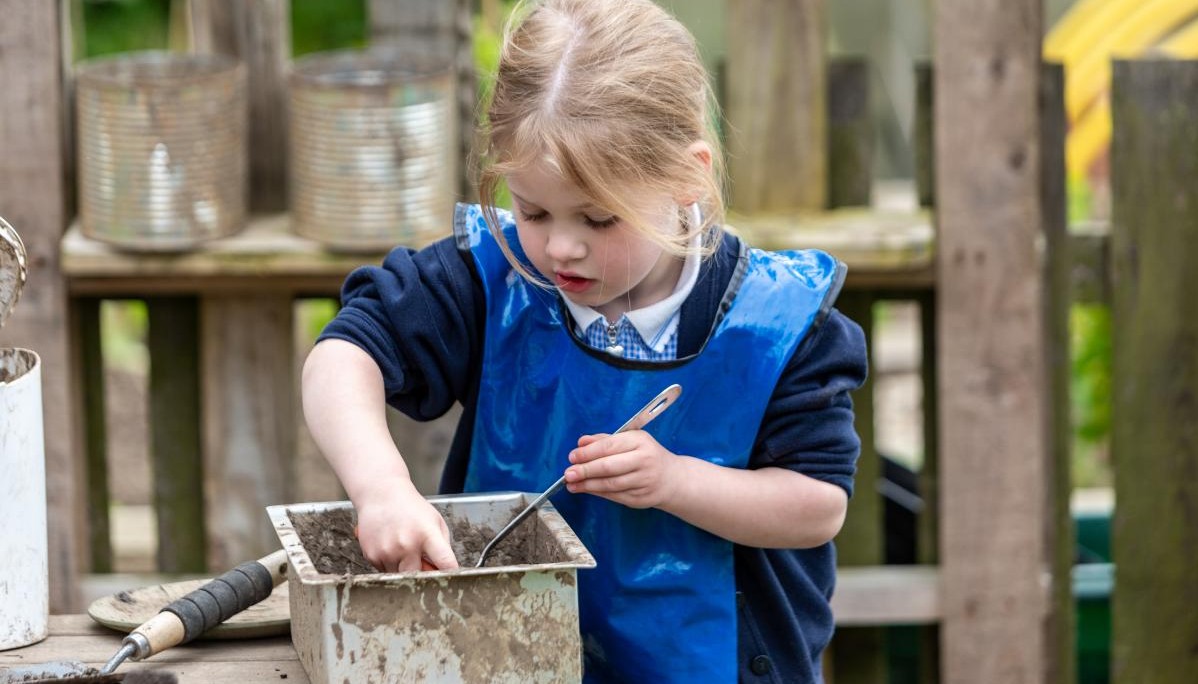 Child enaged in mud kitchen activity 