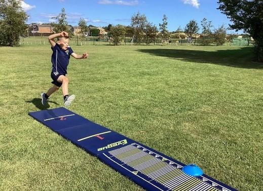 Pupil doing long jump on the school field