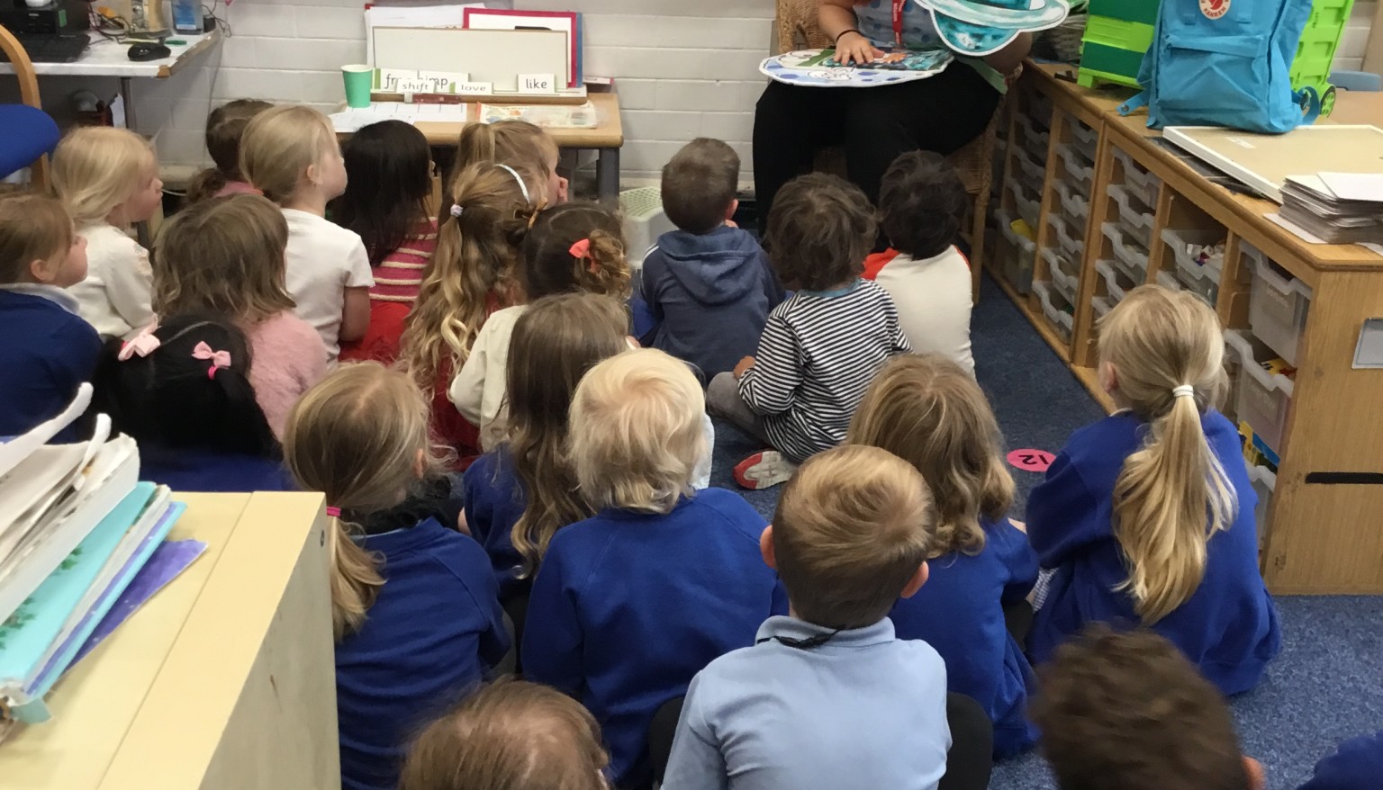 Children sat on a carpet area 