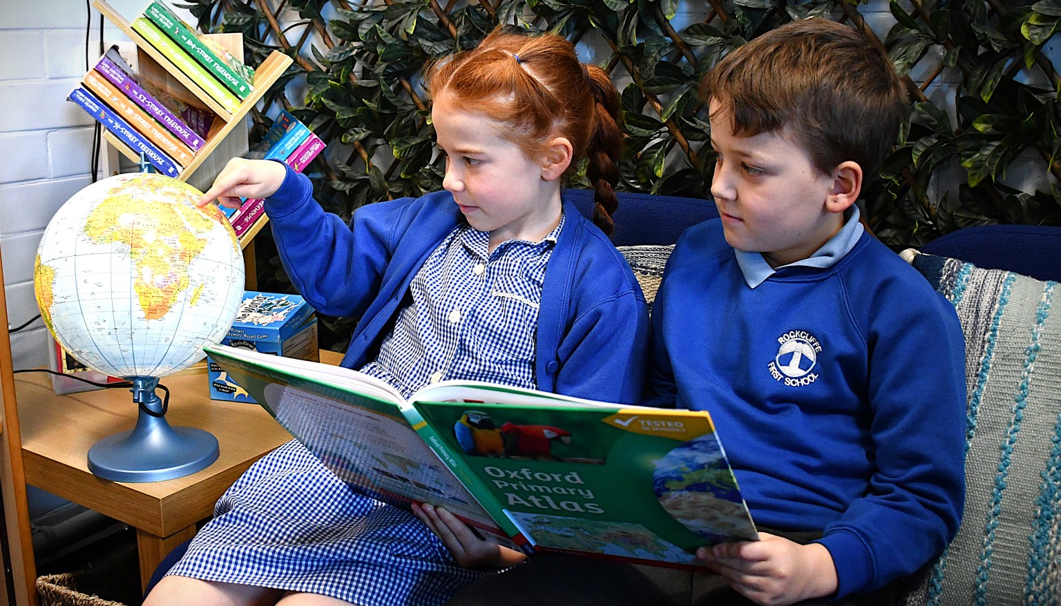 children looking at a globe